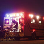 Paramedics carrying patient in ambulance at night