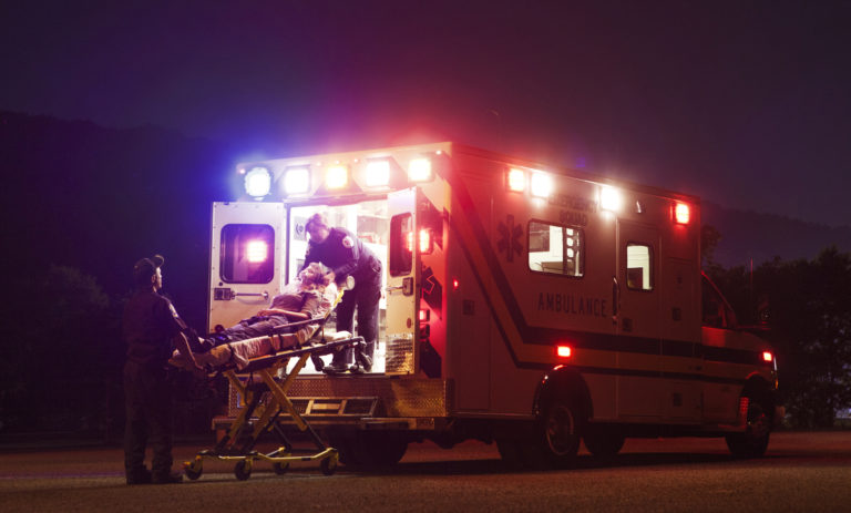 Paramedics carrying patient in ambulance at night